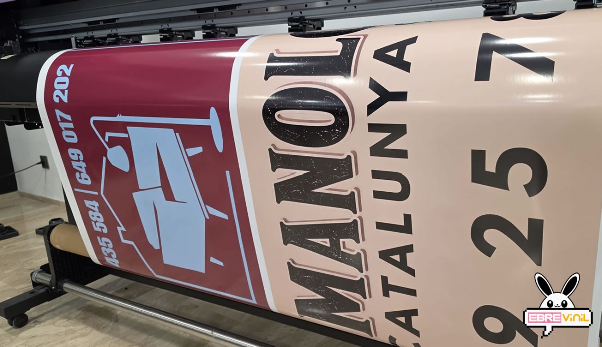 Instalación profesional de un vinilo mural de gran formato en la pared de un comercio moderno