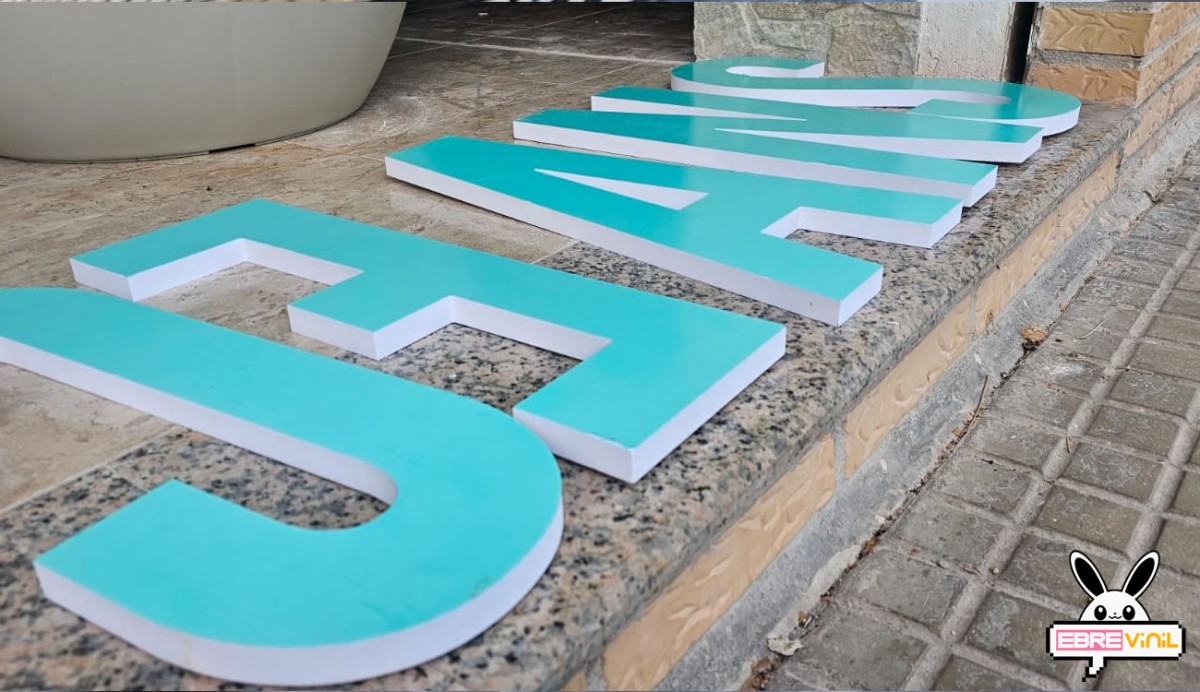 Letras corpóreas instaladas en fachada de tienda y escaparate comercial con iluminación